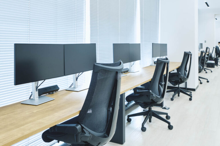 3階執務室の大きな窓際に並ぶフリーデスクスペース。窓から柔らかな自然光が挿し、明るいスペースです。